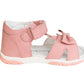 A pink toddler girl Protetika sandal with an arch support, a hook-and-loop strap closure and a decorative bow detail in the front.